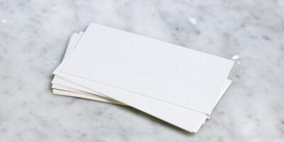 Ein Stapel weißes Papier liegt auf einer Marmorplatte.